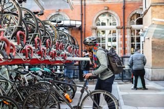 A man locks his bike up at a train station