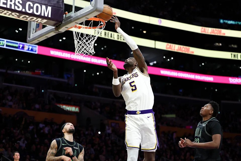 Lakers center Deandre Ayton shoots as Pelicans guard Jose Alvarado and center Derik Queen watch on Sunday.
