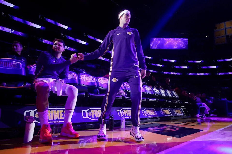 Lakers guards Luka Doncic and Austin Reaves extend their fists toward each other for a bump as players are introduced.