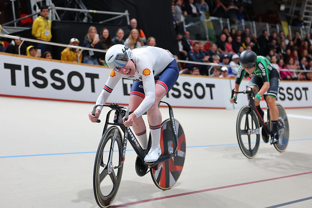 Two cyclists compete on track, on in white the other in green