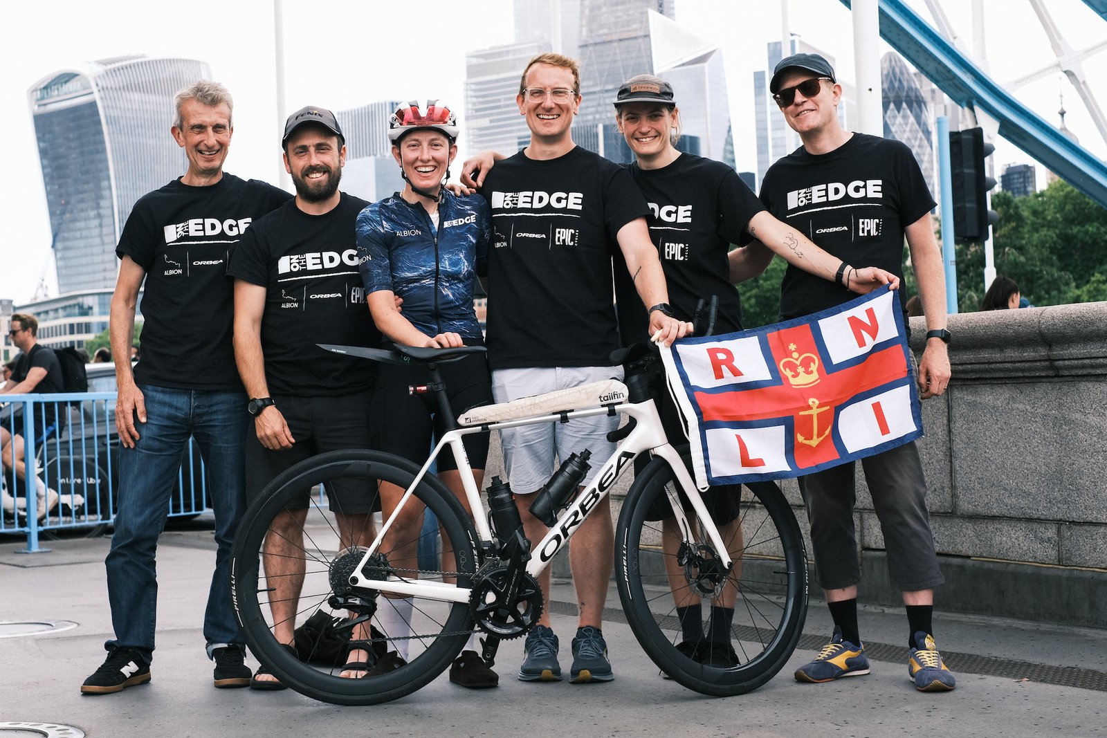 Group of people stand behind a bike on London bridge
