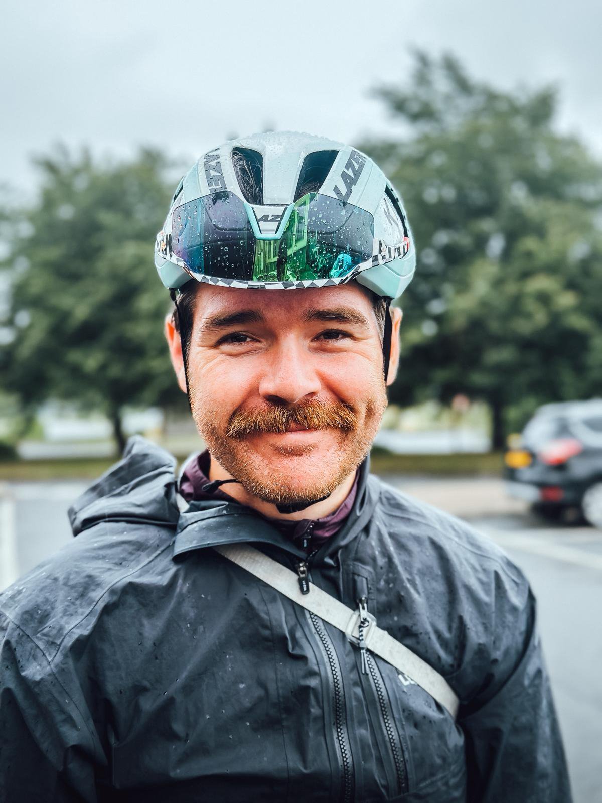 Man smiles into camera wearing helmet