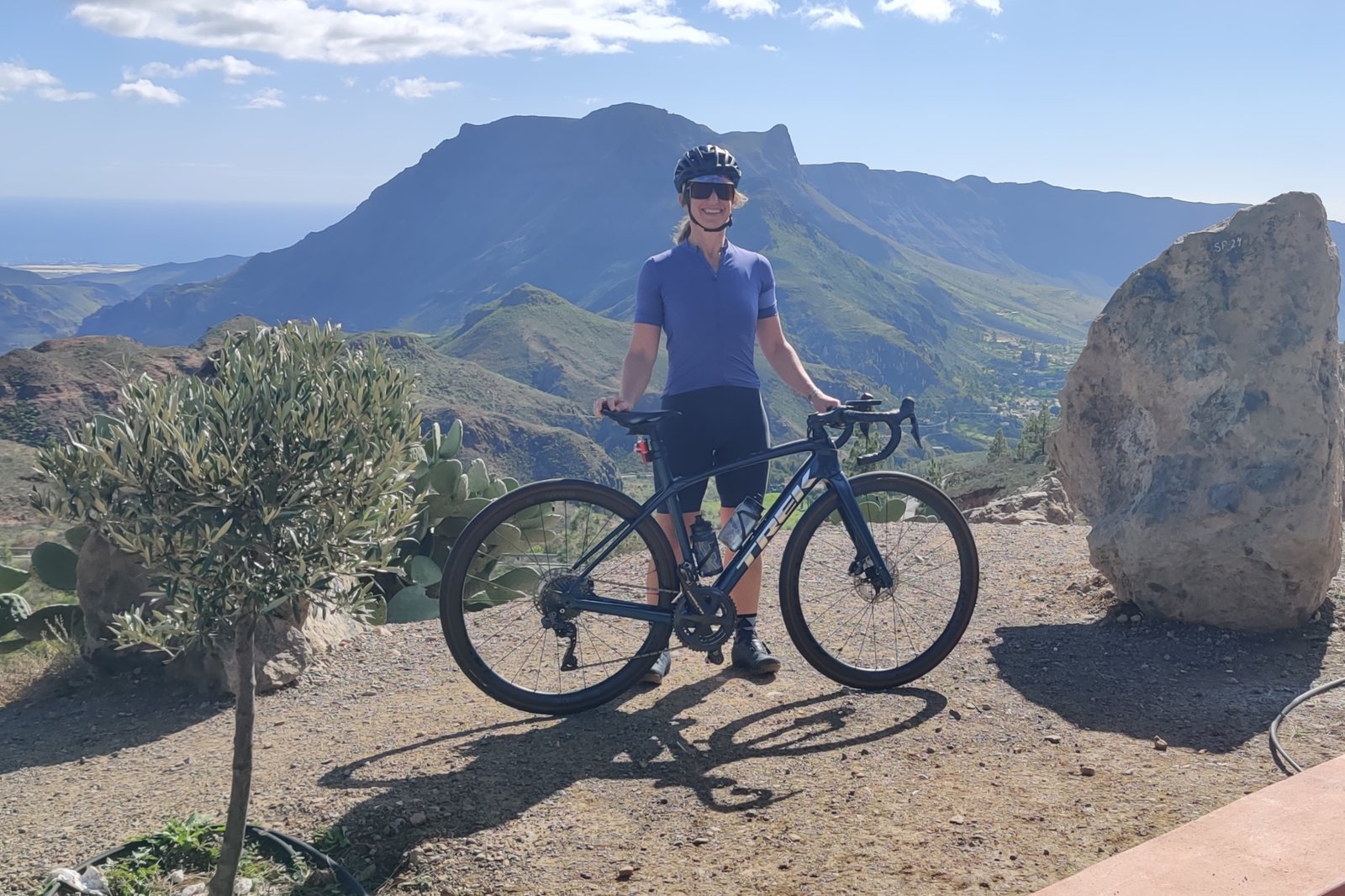 Claire Cottell stands with her Trek bike with a mountainous backdrop behind