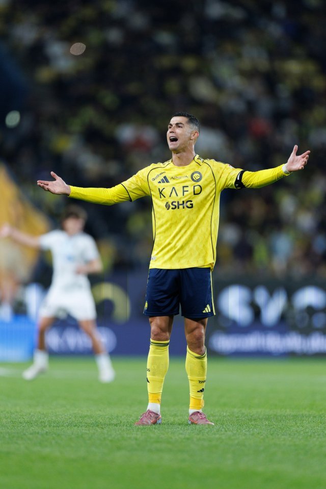 Al Nassr player Cristiano Ronaldo in a yellow and blue uniform on the field during a game.