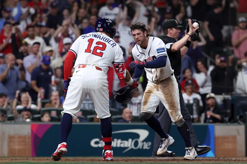 United States designated hitter Kyle Schwarber (12) congratulates second baseman Ernie Clement (5) after scoring a run against Great Britain during the fifth inning at Daikin Park.