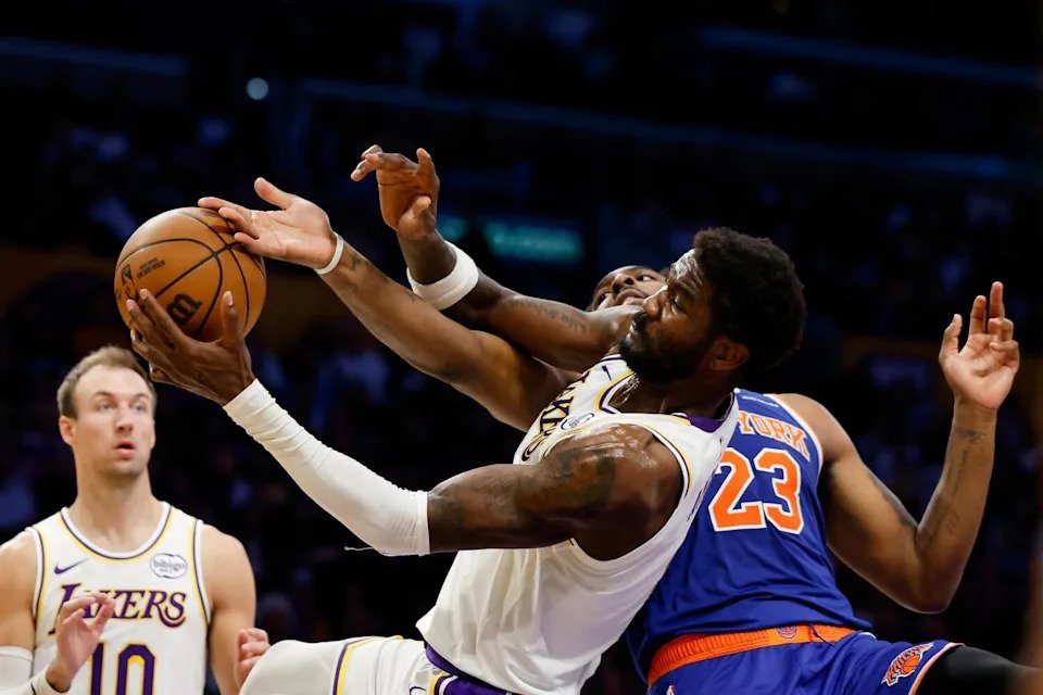 Lakers center Deandre Ayton, center, and Knicks center Mitchell Robinson battle for a rebound.