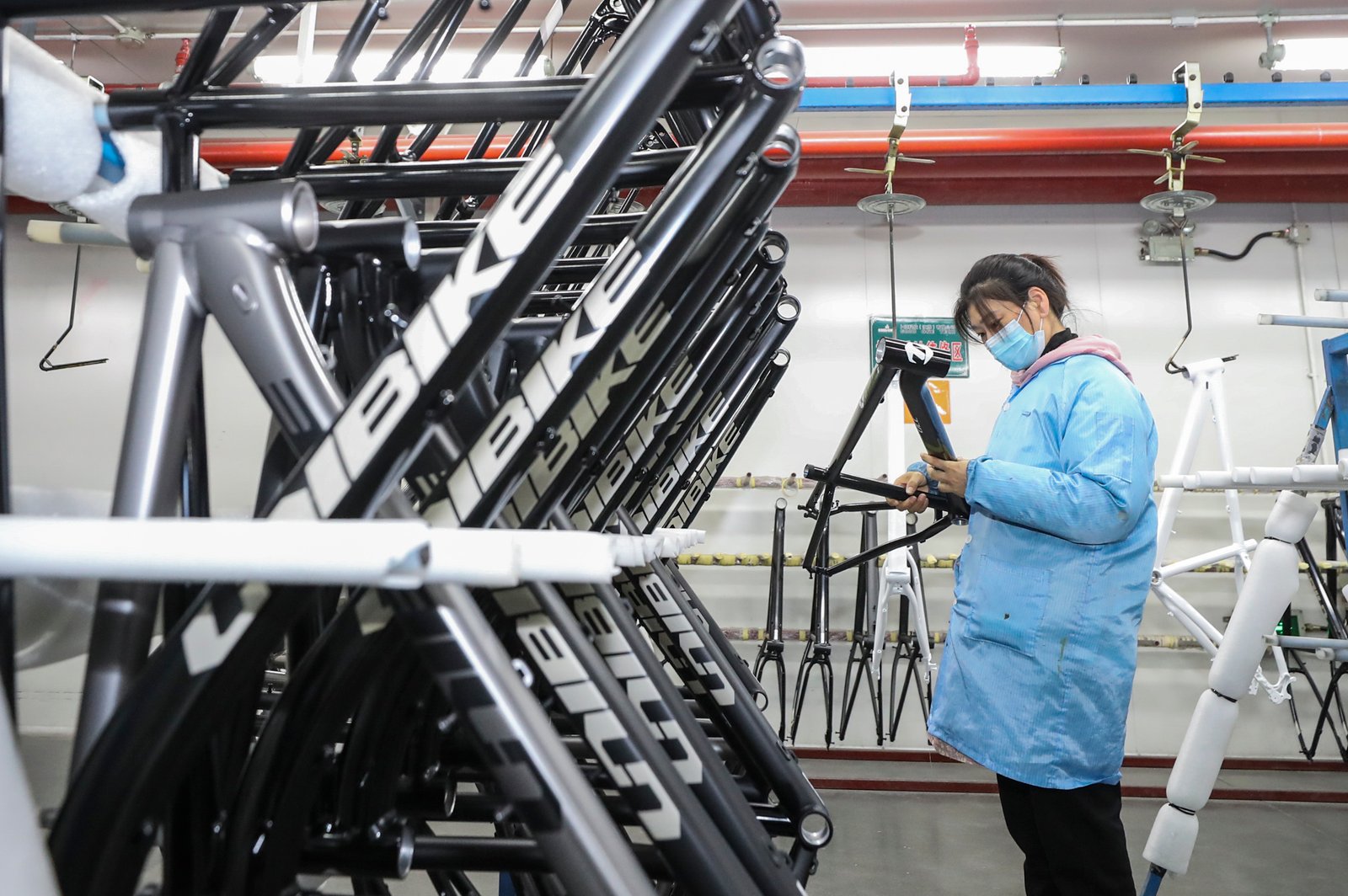 A worker is processing parts for a bicycle frame at a workshop in Huai'an, Jiangsu Province, China.
