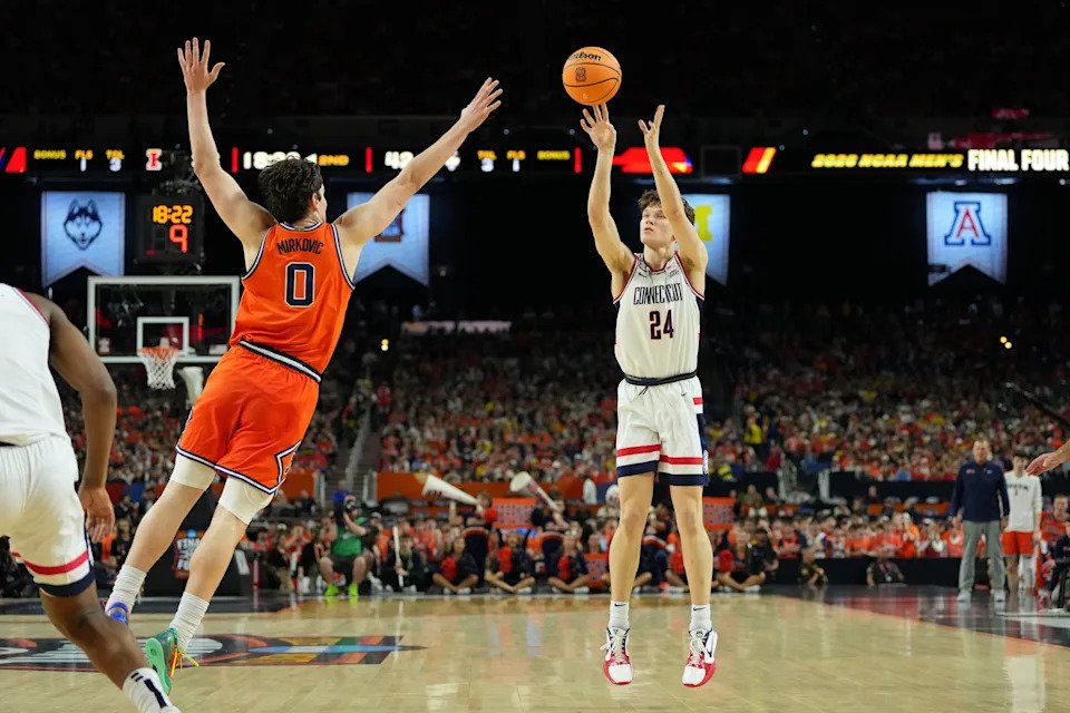 UConn Huskies guard Braylon Mullins (24) shoots the ball against Illinois Fighting Illini forward David Mirkovic (0) during the second half of a semifinal of the Final Four of the men's 2026 NCAA Tournament at Lucas Oil Stadium.