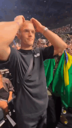 a man in a black shirt holds a green and yellow flag in his hand