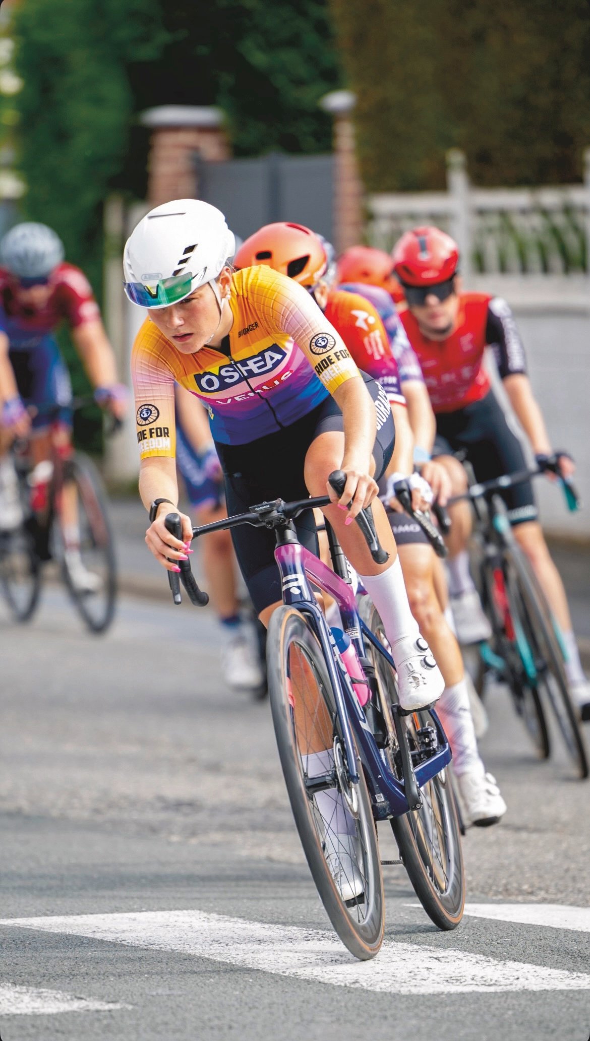 Grace Ward in orange O'Shea jersey competing in a road race