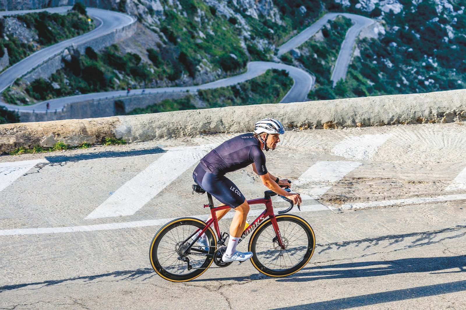 Michael Stanley in black kit and white helmet, competing in a road race