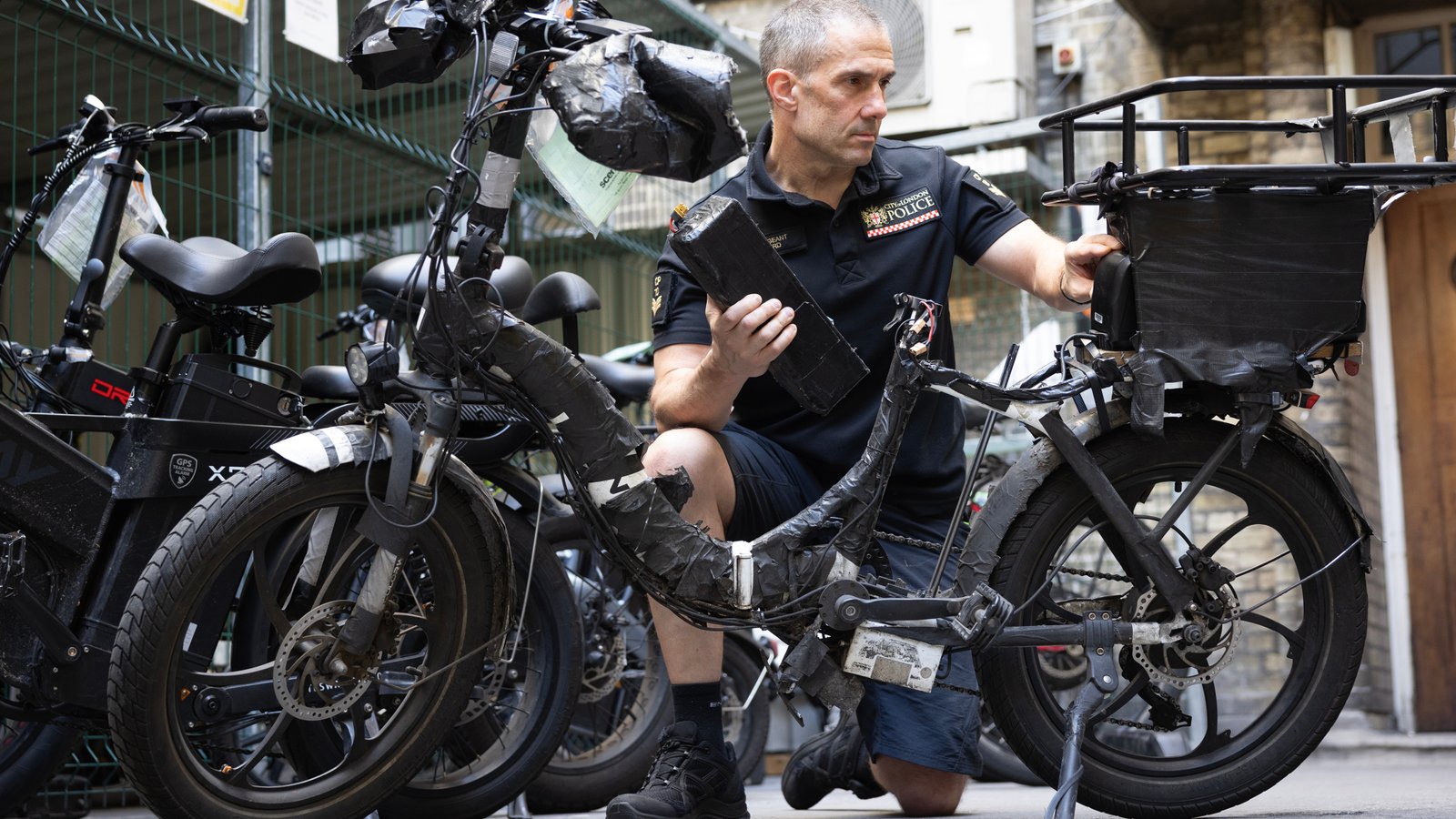 Sgt Stuart Ford of City of London Police assesses seized illegal e-bikes atBishopsgate Police Station in London
